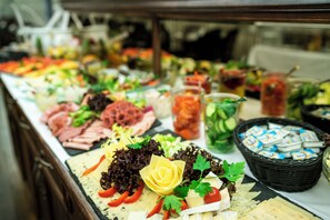 Un buffet proposant une variété de plats, notamment des viandes, des fromages et des salades.