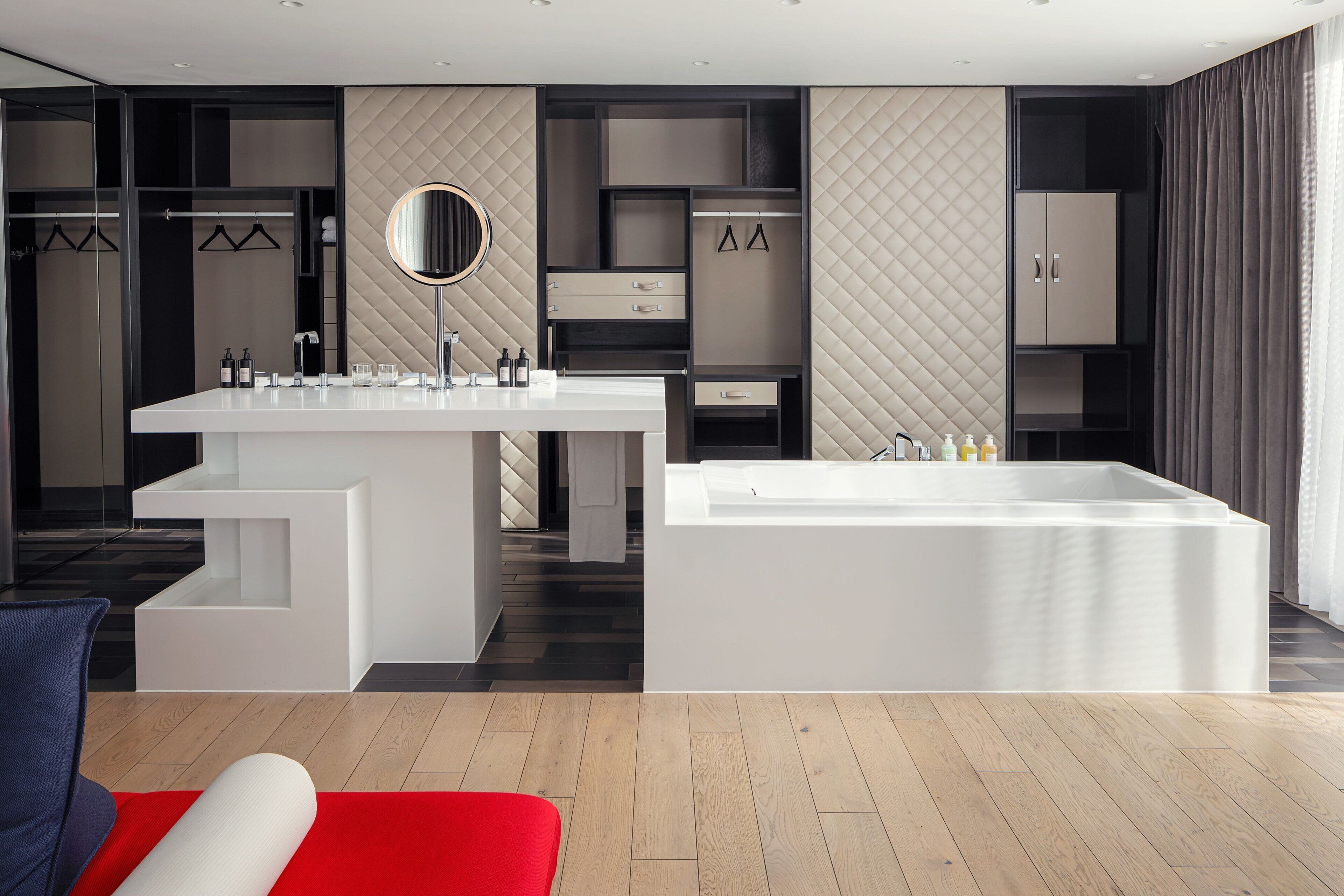 Ein modernes Badezimmer mit einem großen, weißen Waschbecken, einer freistehenden Badewanne und einem Spiegel über dem Waschbecken.