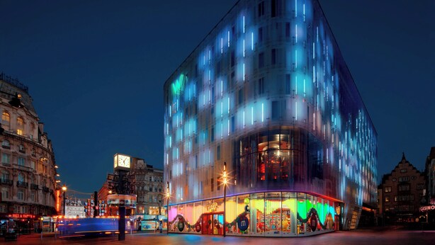 A modern building with a glass facade and illuminated windows at night. - W London (London)