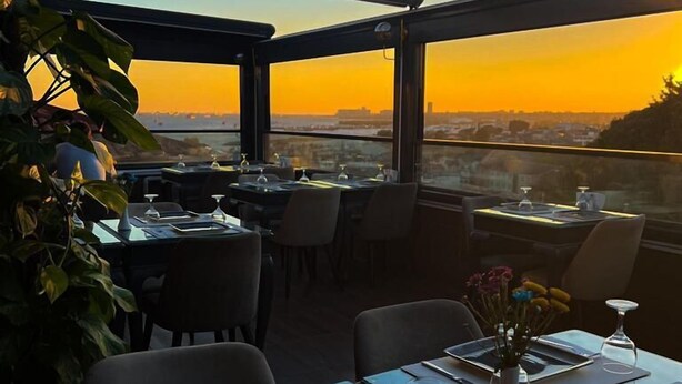 An outdoor dining area with tables set for two, featuring a sunset view. - Dara Old City Hotel (Istanbul)