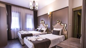A hotel room with two beds, a large mirror, and a chandelier. - Dara Old City Hotel (Istanbul)