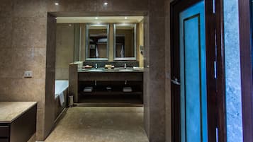 Un baño moderno con dos lavamanos, un espejo grande y una puerta de madera.