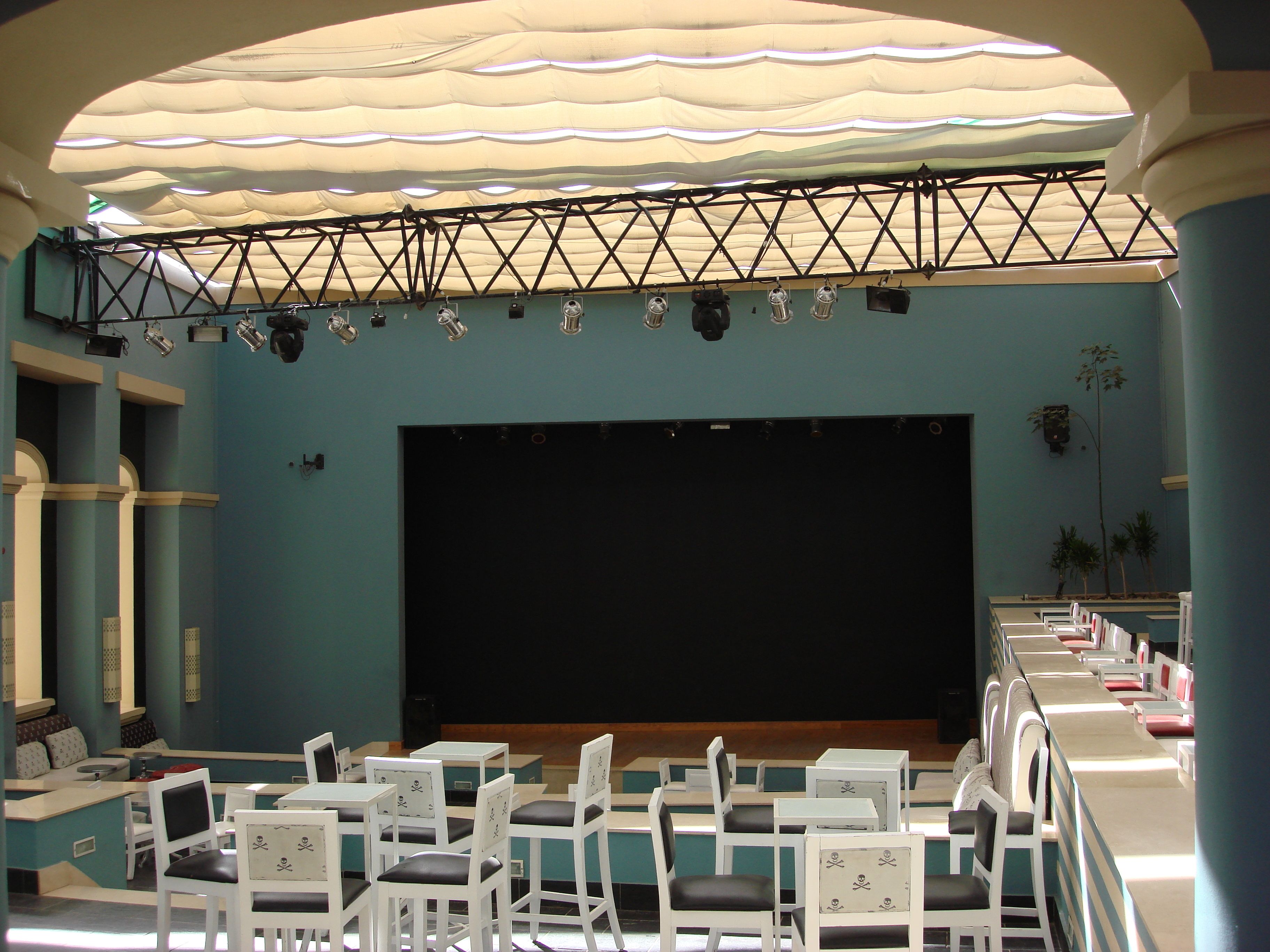 A theater with a stage, seating, and a truss system above.