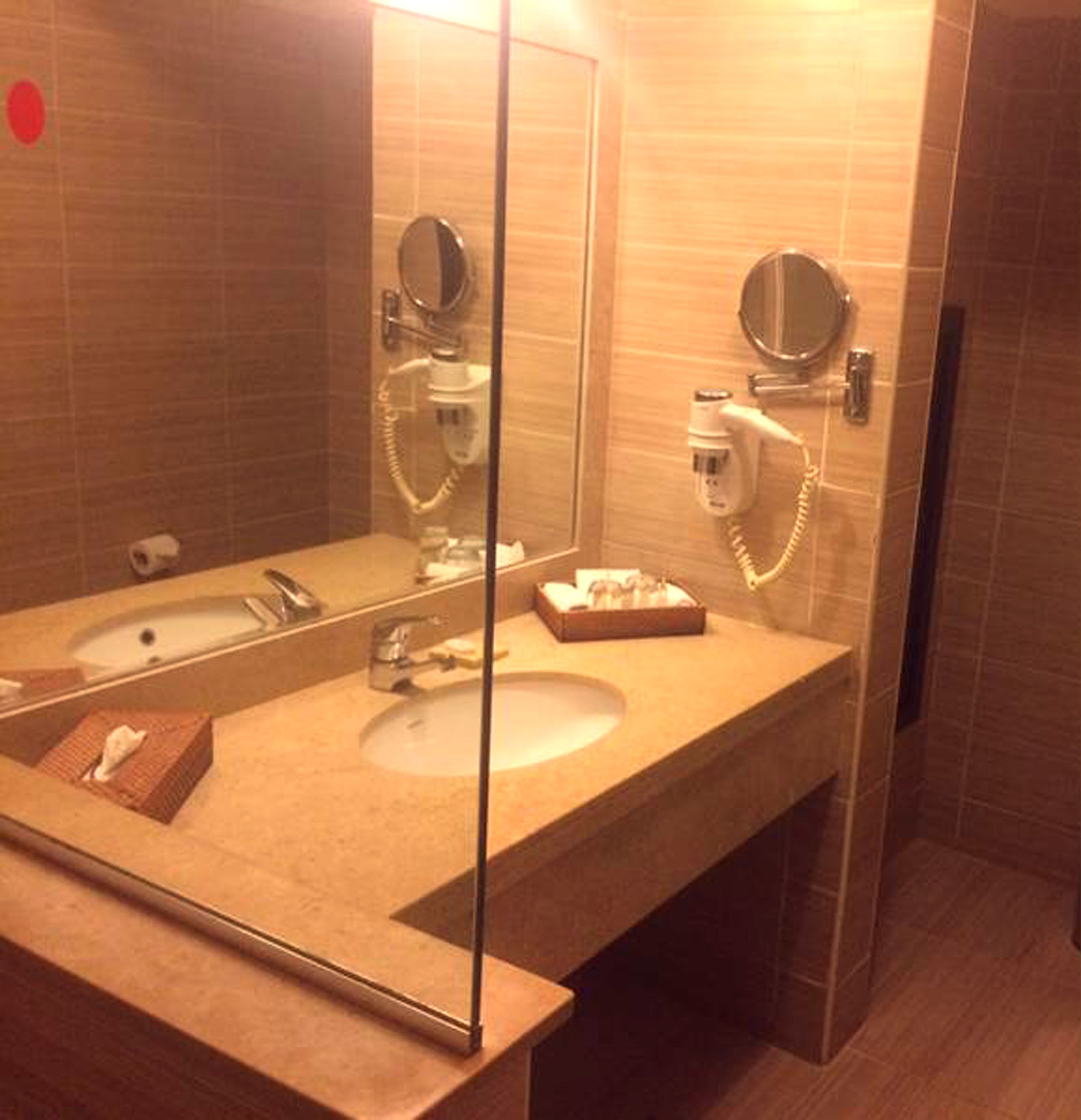 A bathroom with a sink, mirror, and hairdryer.