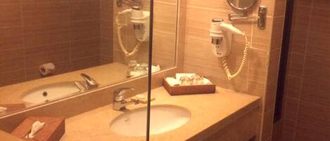 A bathroom with a sink, mirror, and hairdryer.