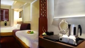 Une chambre d’hôtel avec un lit, un bureau doté d’une machine à café et un miroir décoratif.