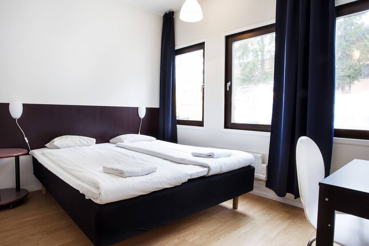 Ein Hotelzimmer mit einem Bett, einem Schreibtisch und einem Stuhl.