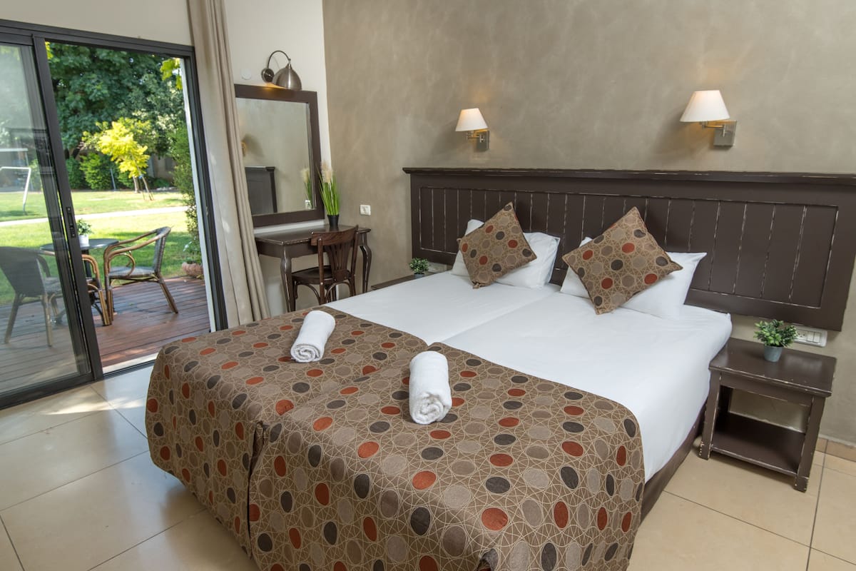 Ein Hotelzimmer mit einem großen Bett, zwei Nachttischen, einem Schreibtisch und einem Sessel.