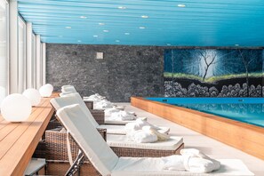 A spa area with lounge chairs, a pool, and a mural. - Hotel Europe Davos (Davos)