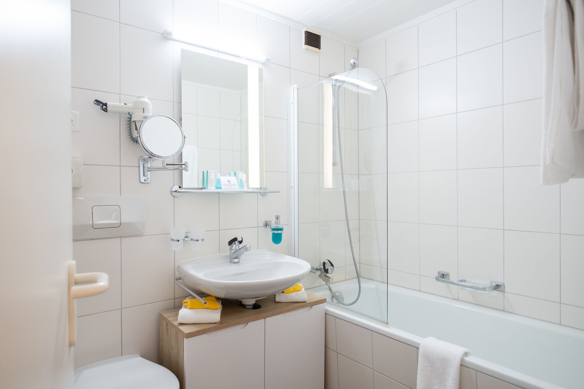 Une salle de bain moderne avec un lavabo blanc, un miroir et une douche.