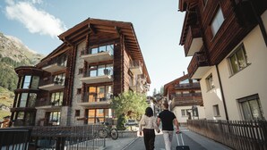 Un hotel de varios pisos con balcones, un letrero que indica que es un hotel y una bicicleta estacionada afuera.
