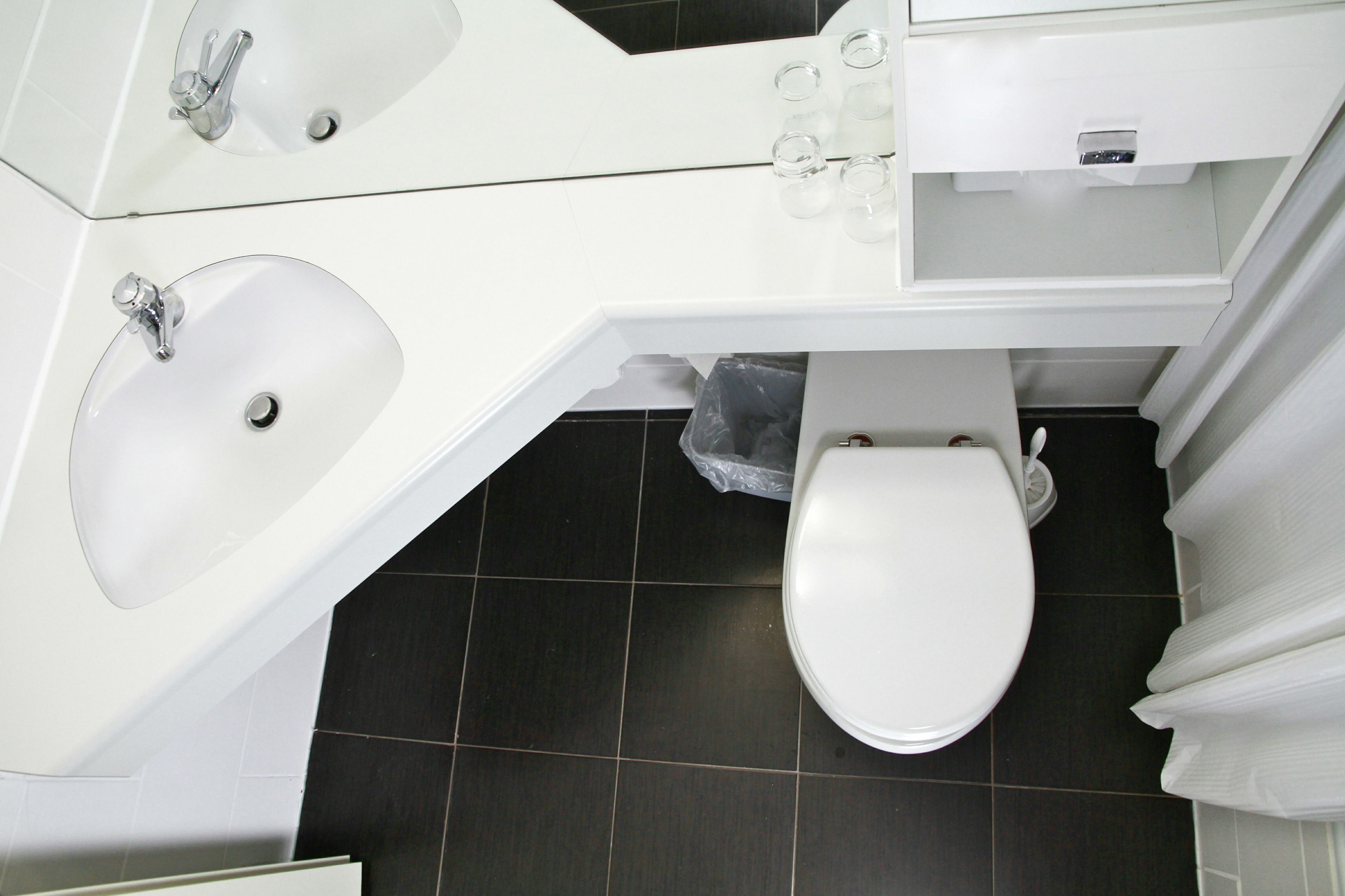 Ein modernes Badezimmer mit Waschbecken, Spiegel und Toilette.