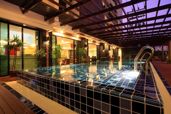 Una piscina al aire libre, camas de piscina gratis, sombrillas