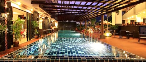 Una piscina al aire libre, camas de piscina gratis, sombrillas
