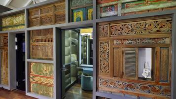 A room with ornate wooden panels and a glass door leading to a bathroom.