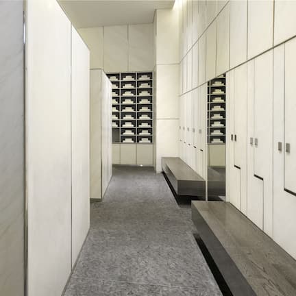 A modern bathroom with a black countertop, white cabinets, and a bench.
