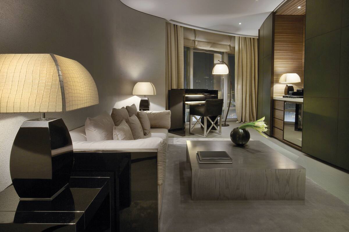 Ein modernes Hotelzimmer mit gewölbter Decke, einer Sitzecke, einem Schreibtisch und einem Essbereich.