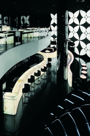 A modern bar area with a curved counter and multiple stools.
