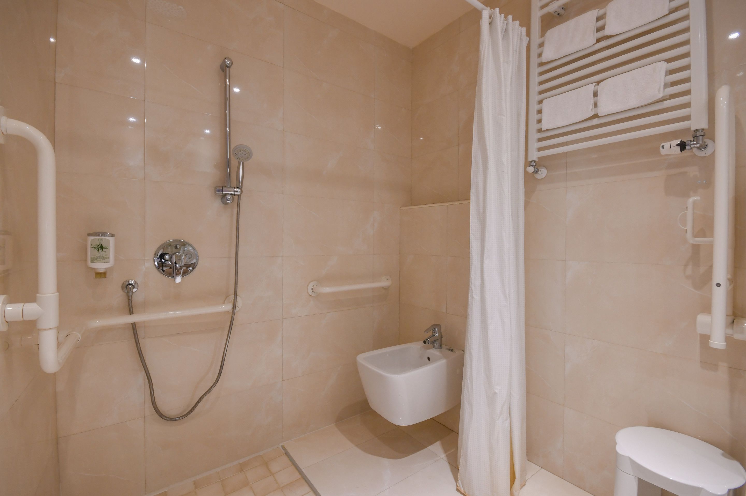A modern bathroom with a walk-in shower, a bidet, and a toilet.