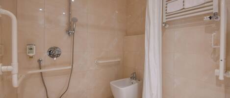 A modern bathroom with a walk-in shower, a bidet, and a toilet.