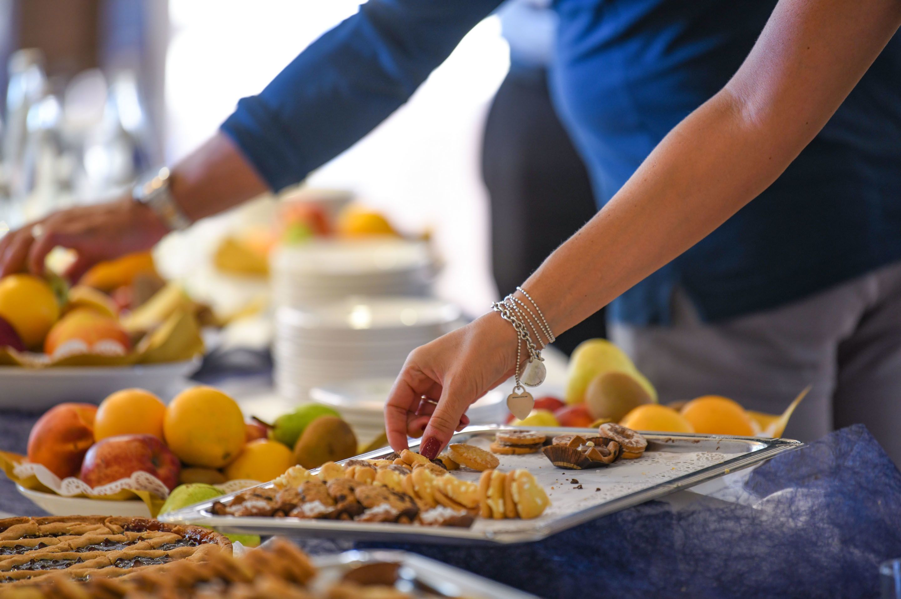 Iemand serveert eten van een schaal bij een buffet.