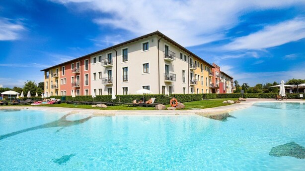 A multi-story hotel with a swimming pool, balconies, and outdoor seating areas. - TH Lazise - Hotel Parchi del Garda (Lazise)