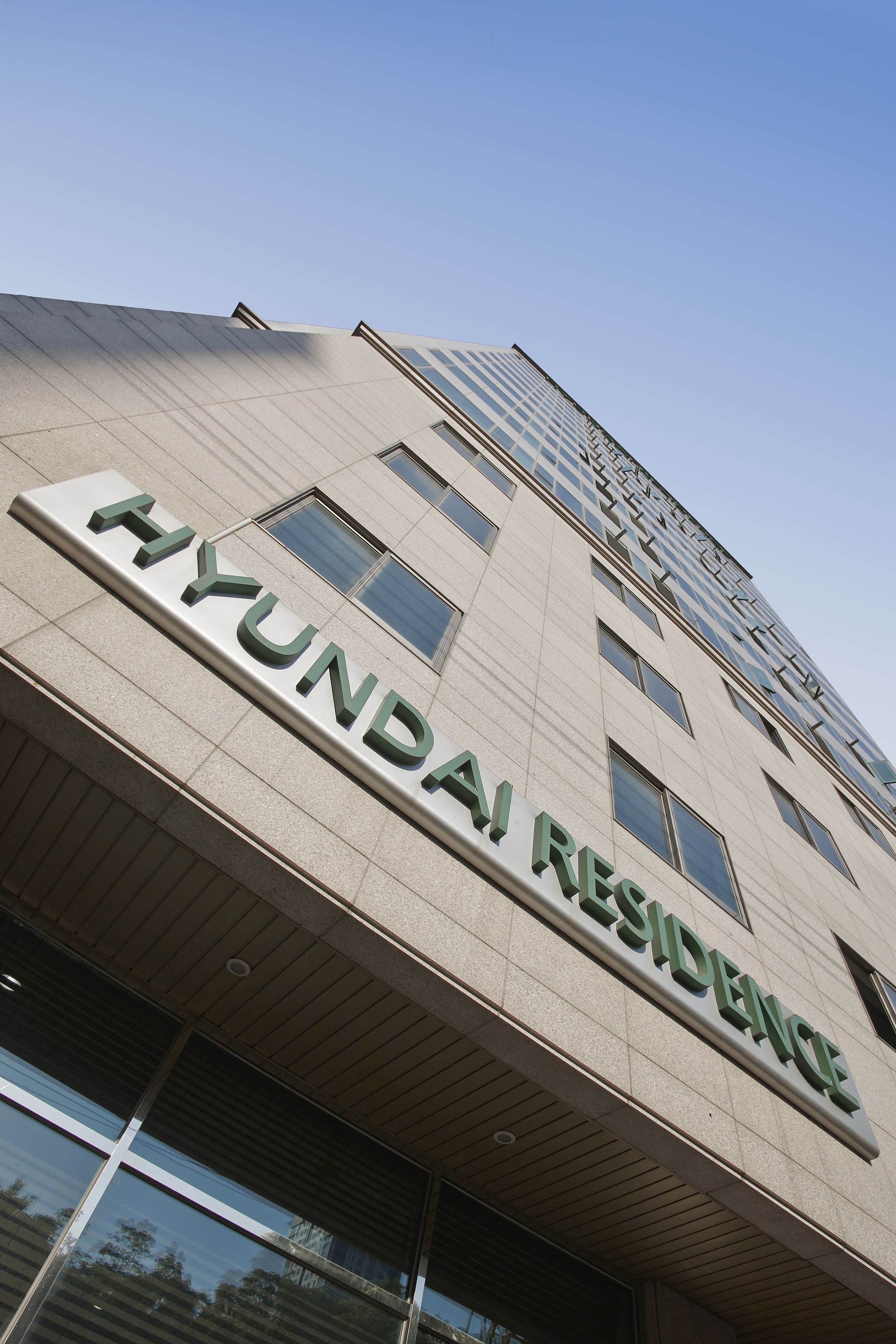 Een gebouw met het bord "HYUNDAI RESIDENCE", wat een woongebied aangeeft.