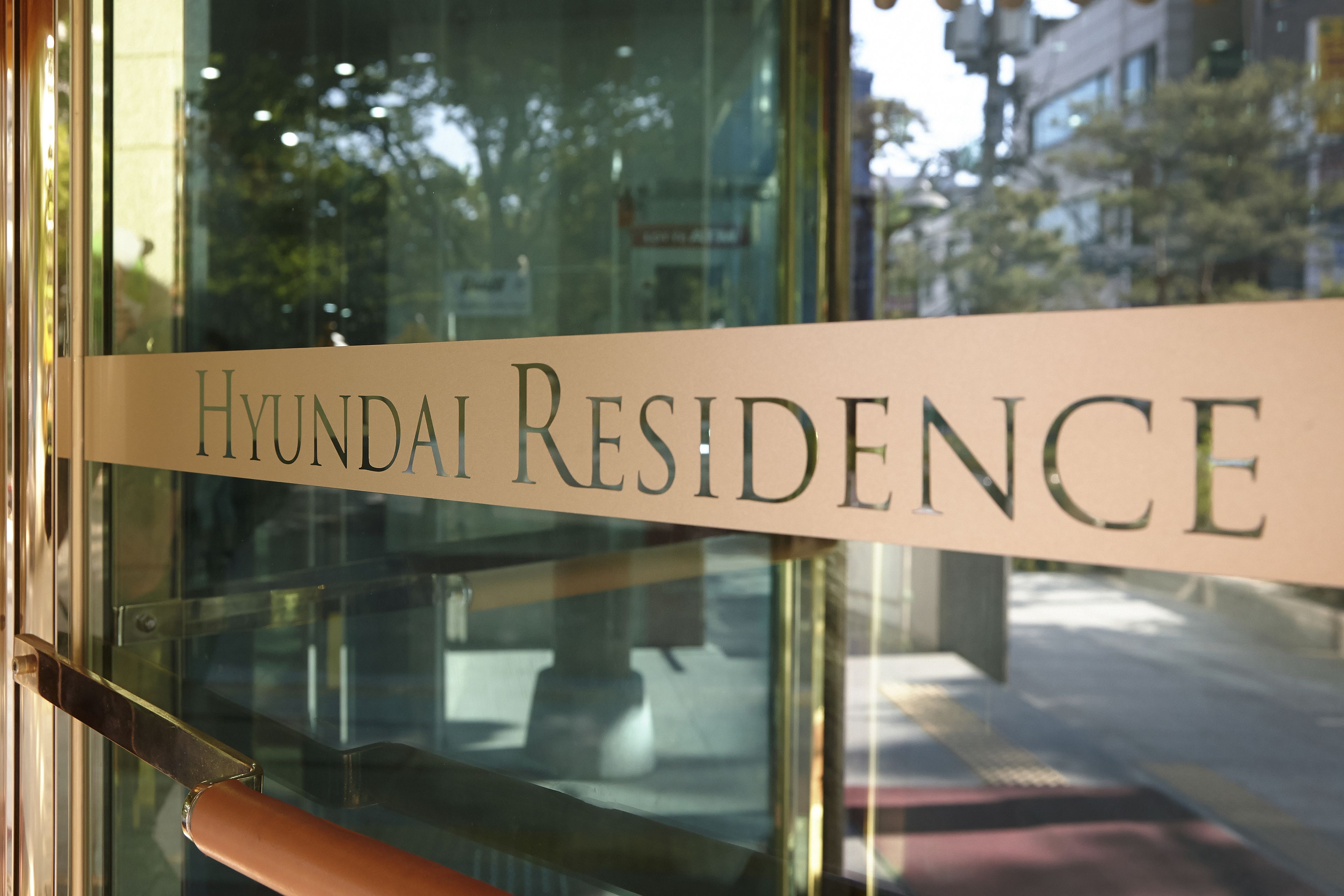 A sign that reads "Hyundai Residence" on a glass door.