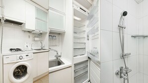 Une cuisine moderne équipée d’un lave-linge, d’un évier et d’un four encastré.