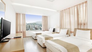Habitación de hotel con dos camas, televisión y vista a la ciudad.