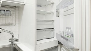 Una cocina moderna con refrigerador empotrado, lavamanos y enfriador de vino.