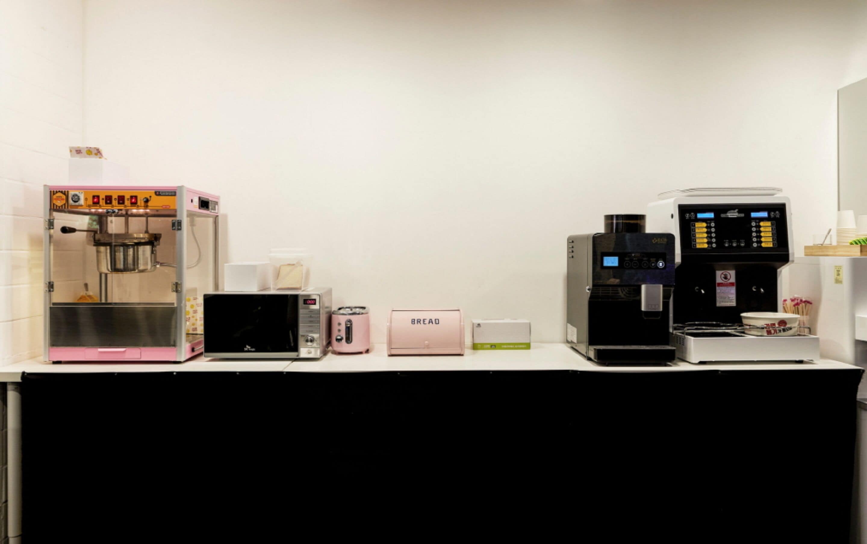 A coffee station with various coffee machines and a bread machine.