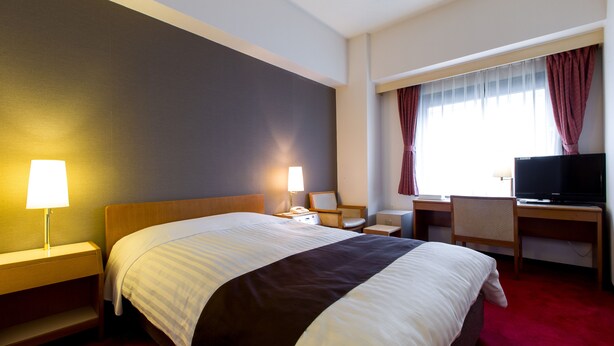 A hotel room with a large bed, bedside lamps, a desk with a chair, a television, and a window with curtains. - Hotel New Star Ikebukuro (Tokyo)