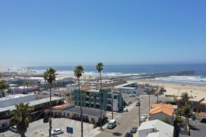 A coastal urban area with a beach, a pier, and a mix of commercial and residential buildings.