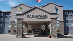 L’entrée d’un hôtel, avec une enseigne indiquant « Four Points by Sheraton » et des drapeaux canadiens.