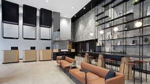 A modern interior with sofas, a bar area, and shelves with plants.