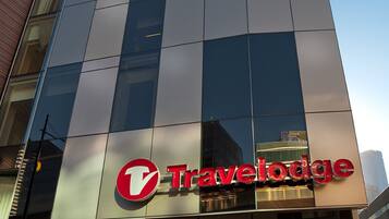 A modern building with a large glass facade and a prominent Travelodge sign.