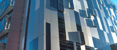 A modern building with a Travelodge sign, featuring a glass facade and a structured, geometric design.
