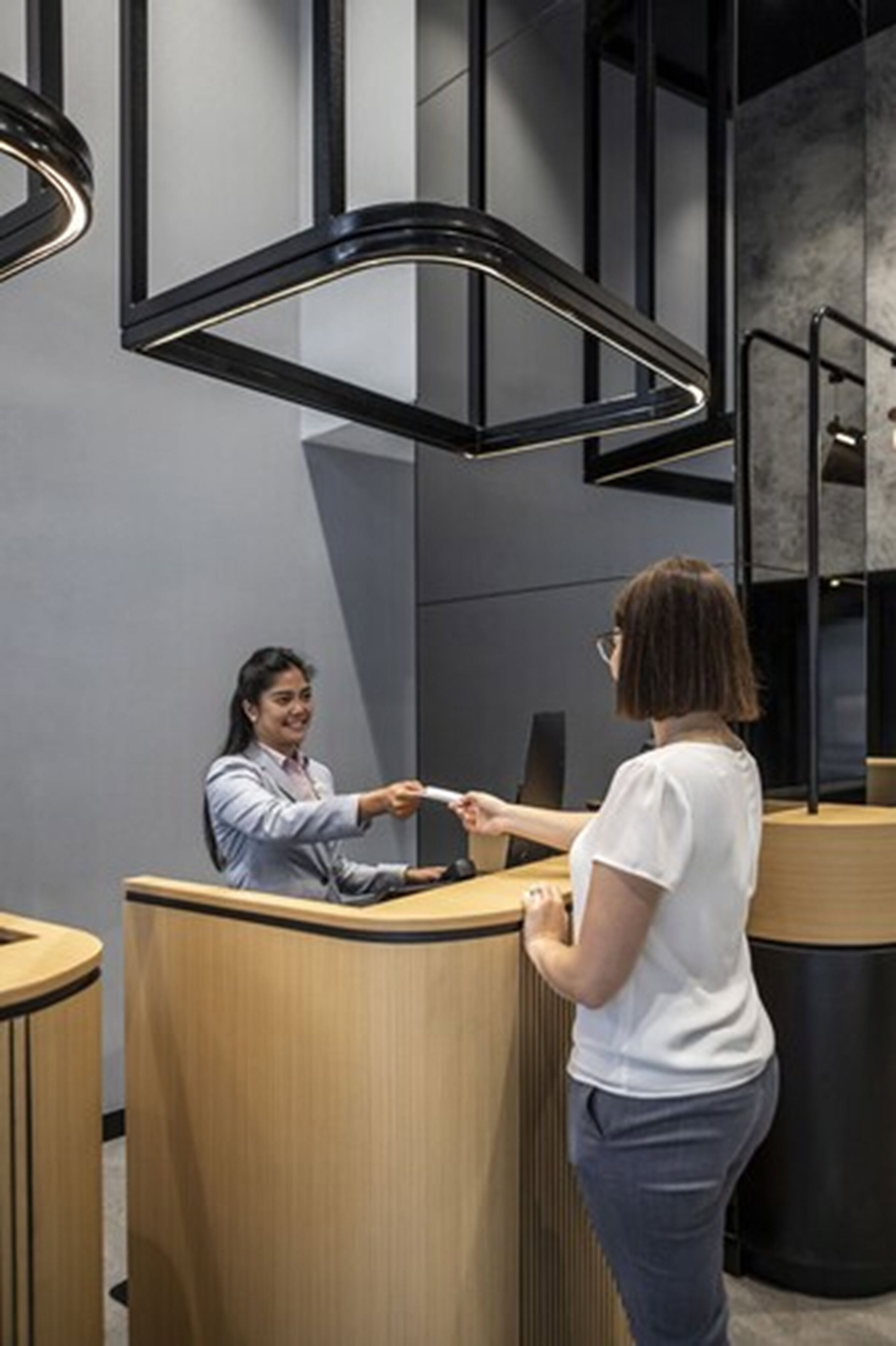 A reception area with a wooden counter and modern pendant lighting.