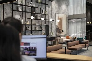 Een modern interieur met een bank, tafels en een boekenkast.