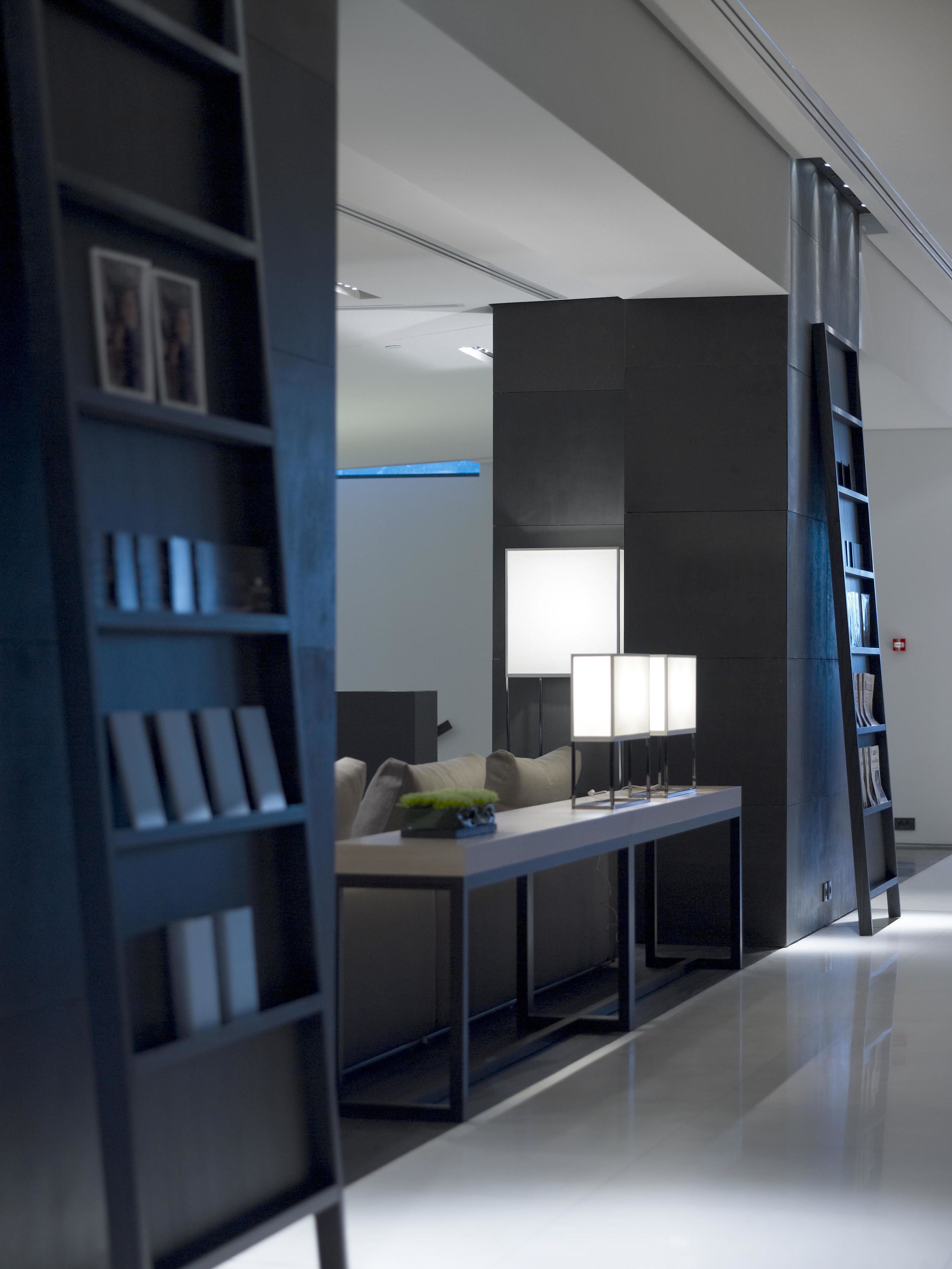 Une chambre d’hôtel moderne et minimaliste, dotée d’un grand lit, d’une table de chevet et d ’une bibliothèque intégrée.