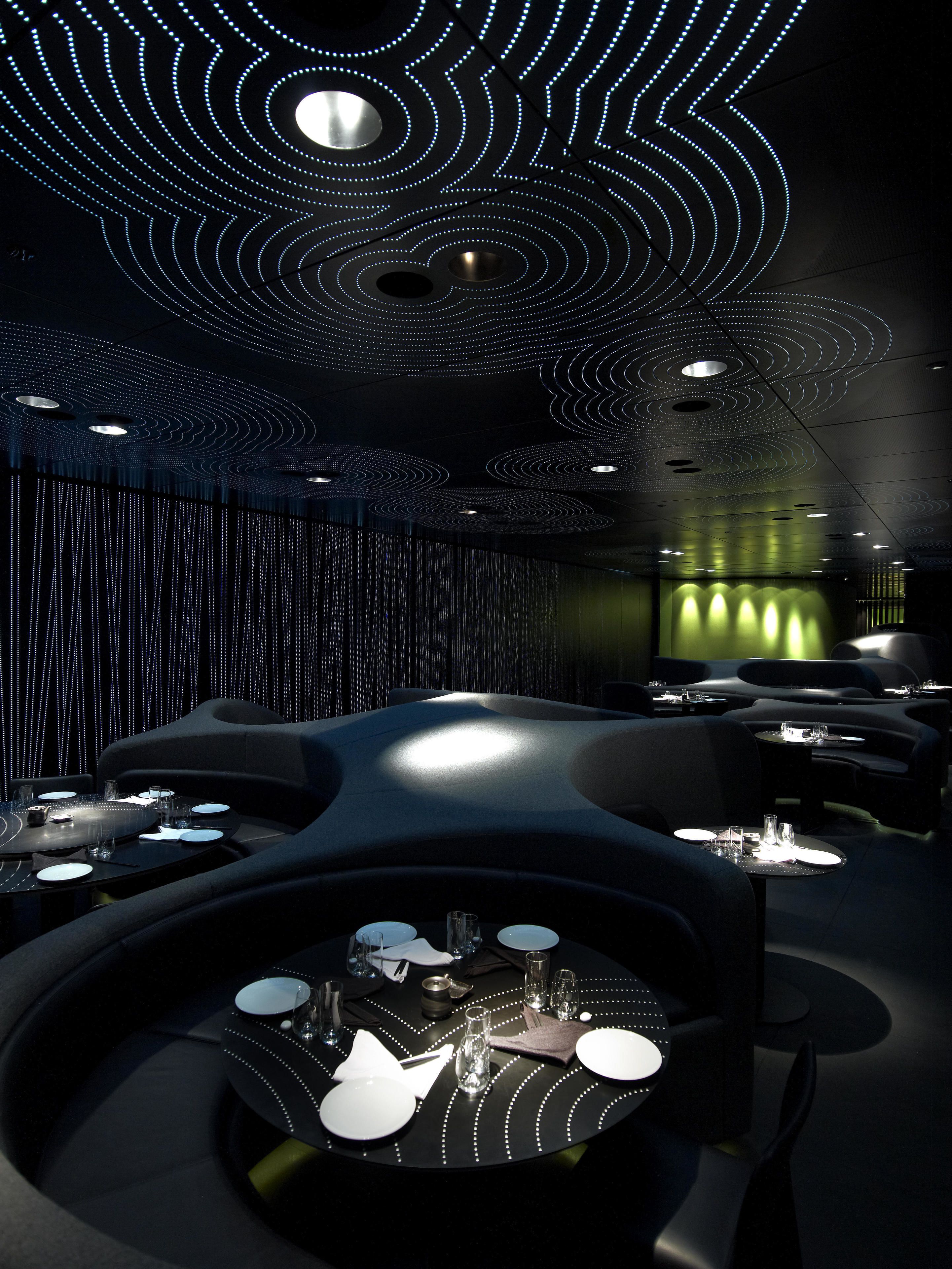 A modern restaurant interior with unique ceiling lighting and contemporary furniture.