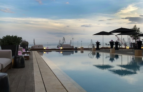 Una piscina techada, una piscina al aire libre de temporada, sombrillas