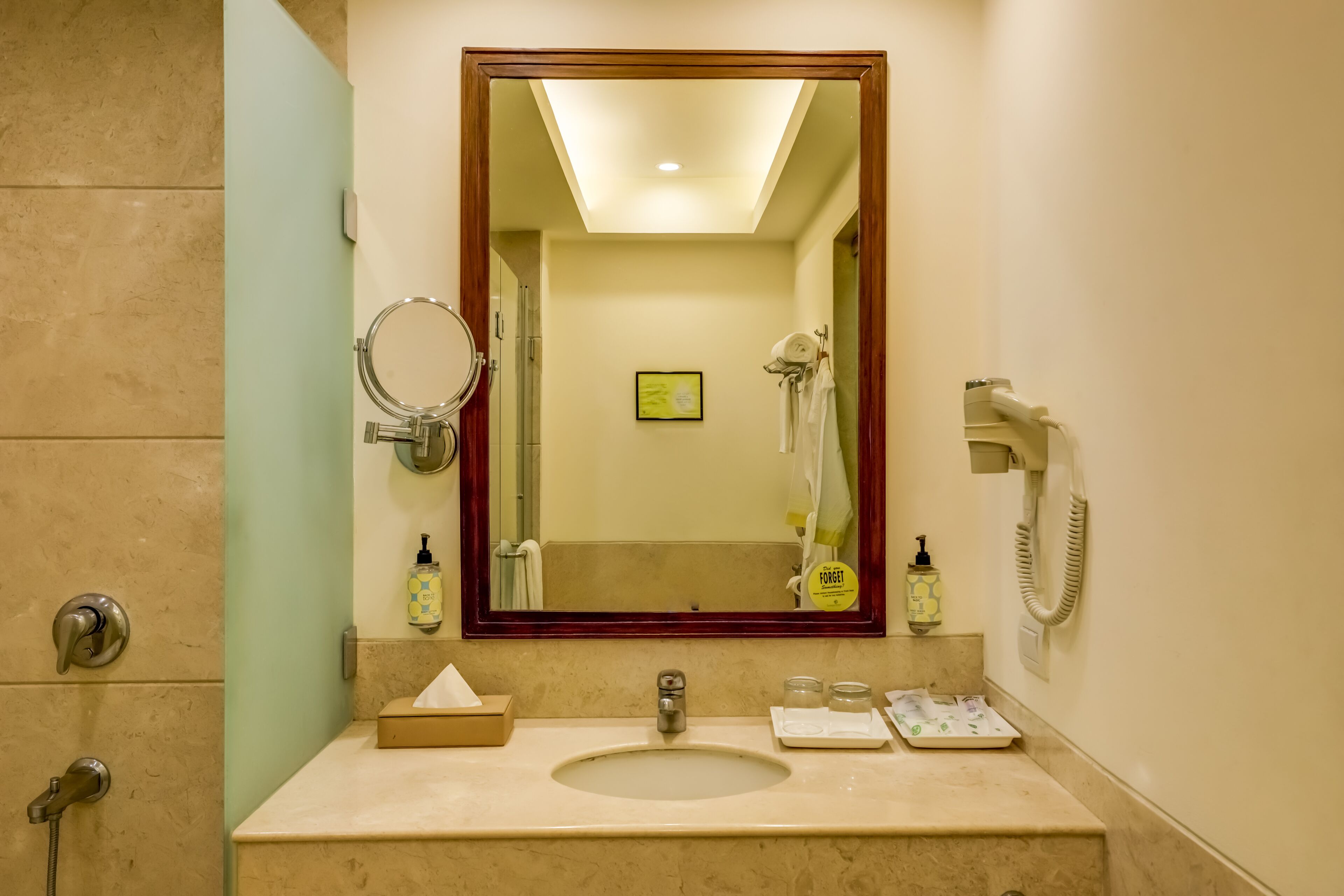 A bathroom with a sink, mirror, and shower.