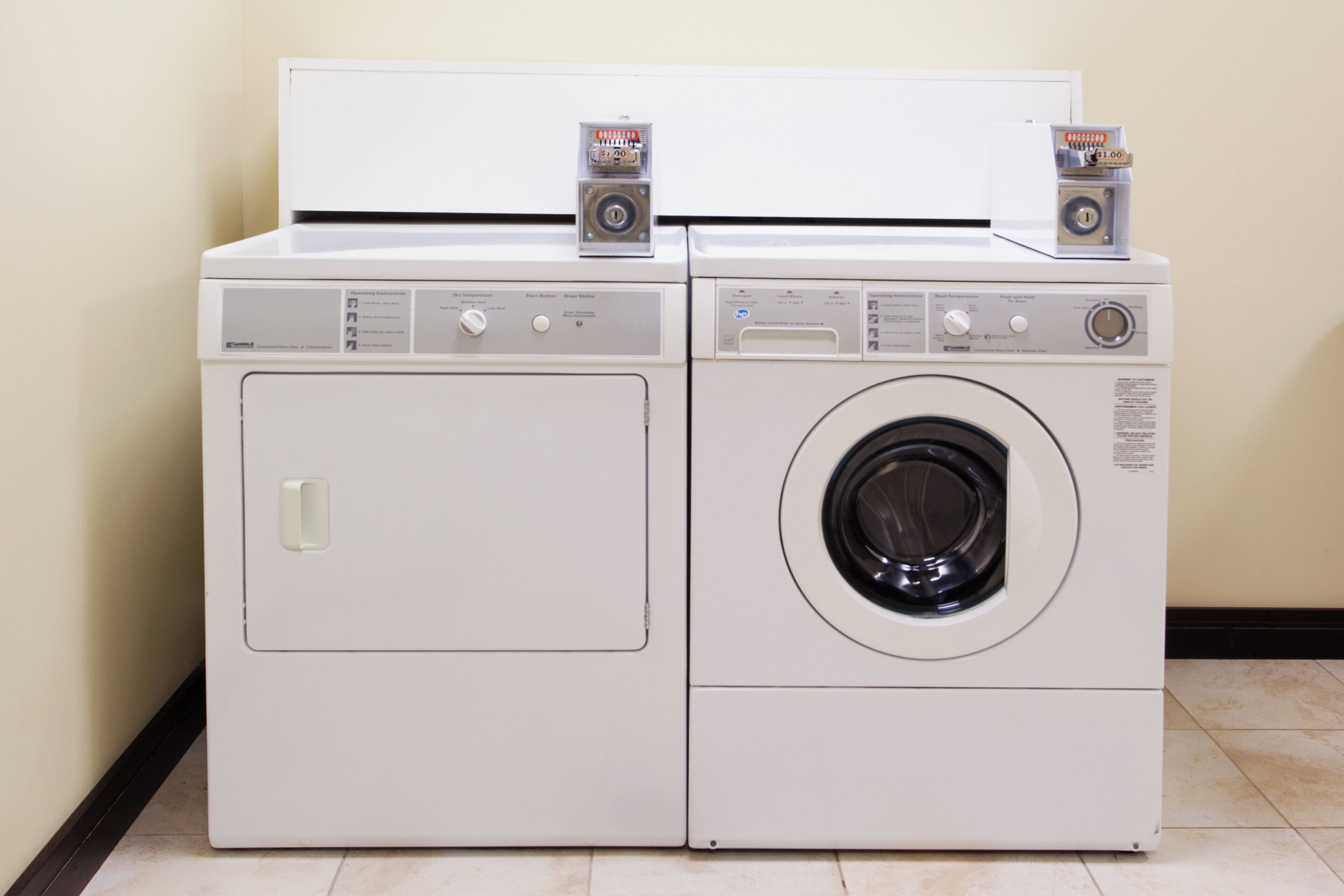 Two stacked laundry machines with control panels and a door.
