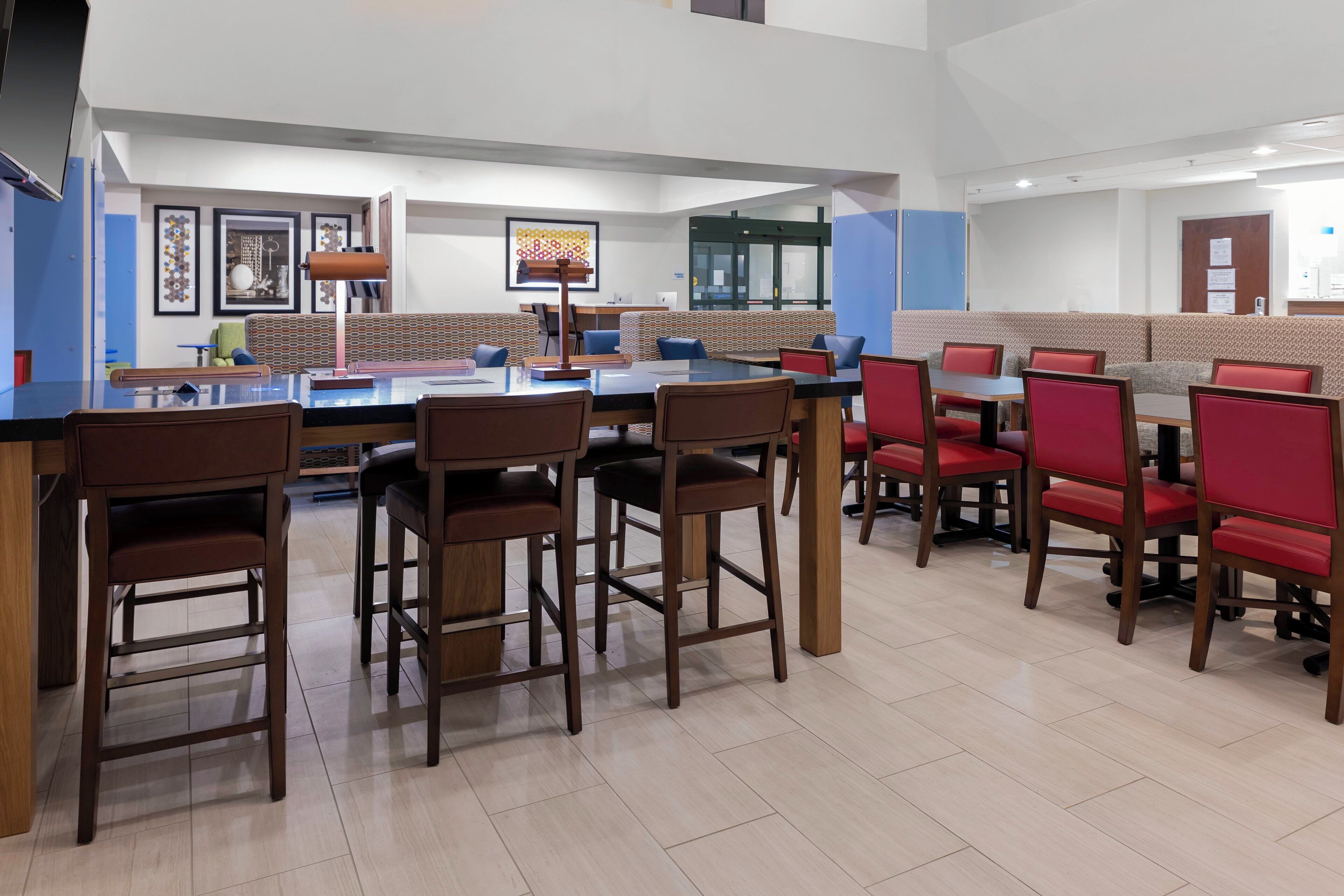 A modern hotel lobby with a bar area, seating arrangements, and artwork on the walls.