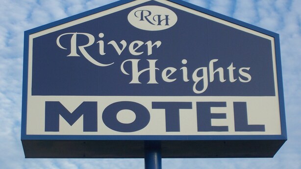 Un letrero de motel con el nombre 'River Heights' y el logo 'RH'.