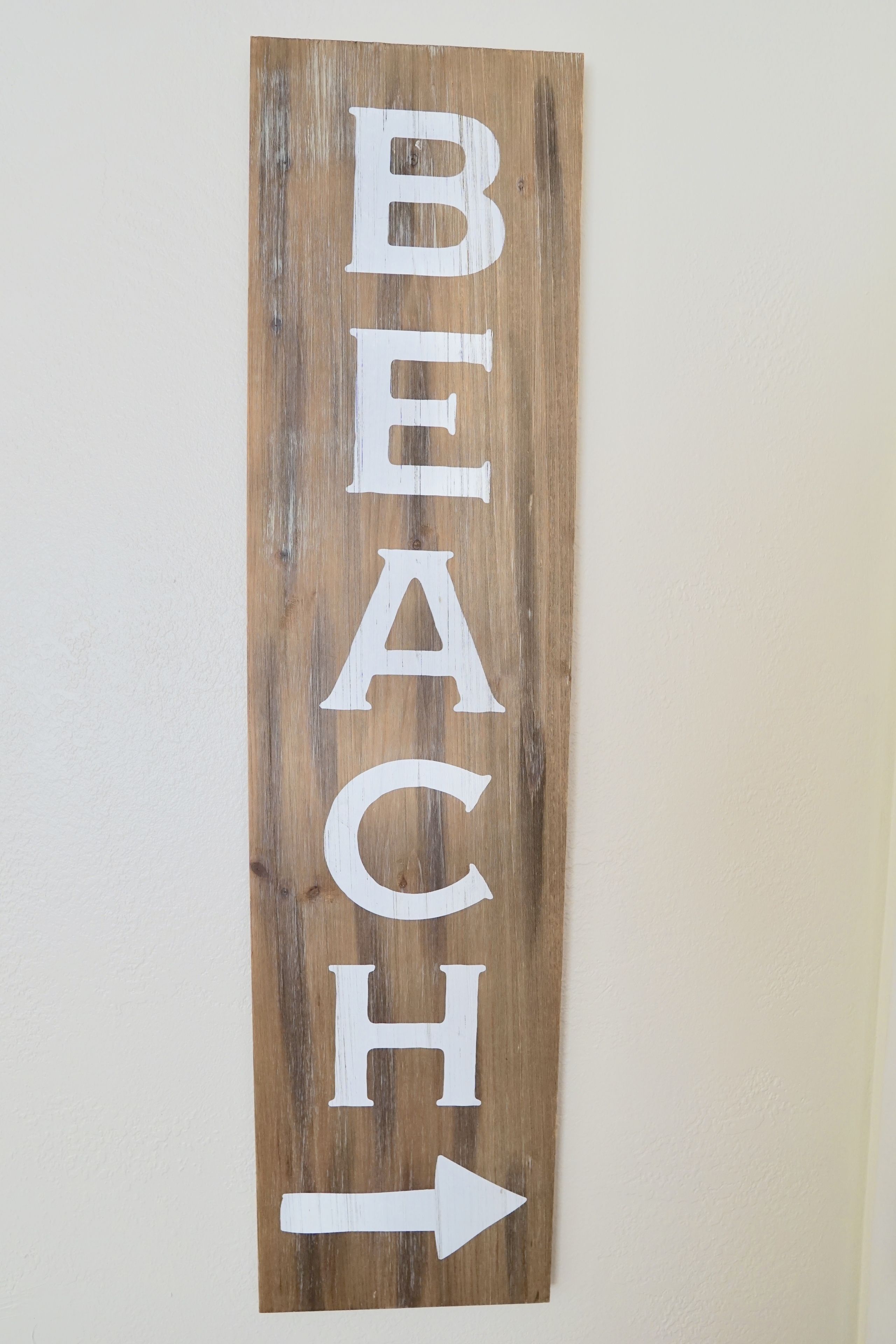 A wooden sign with the word "BEACH" and an arrow pointing to the right.