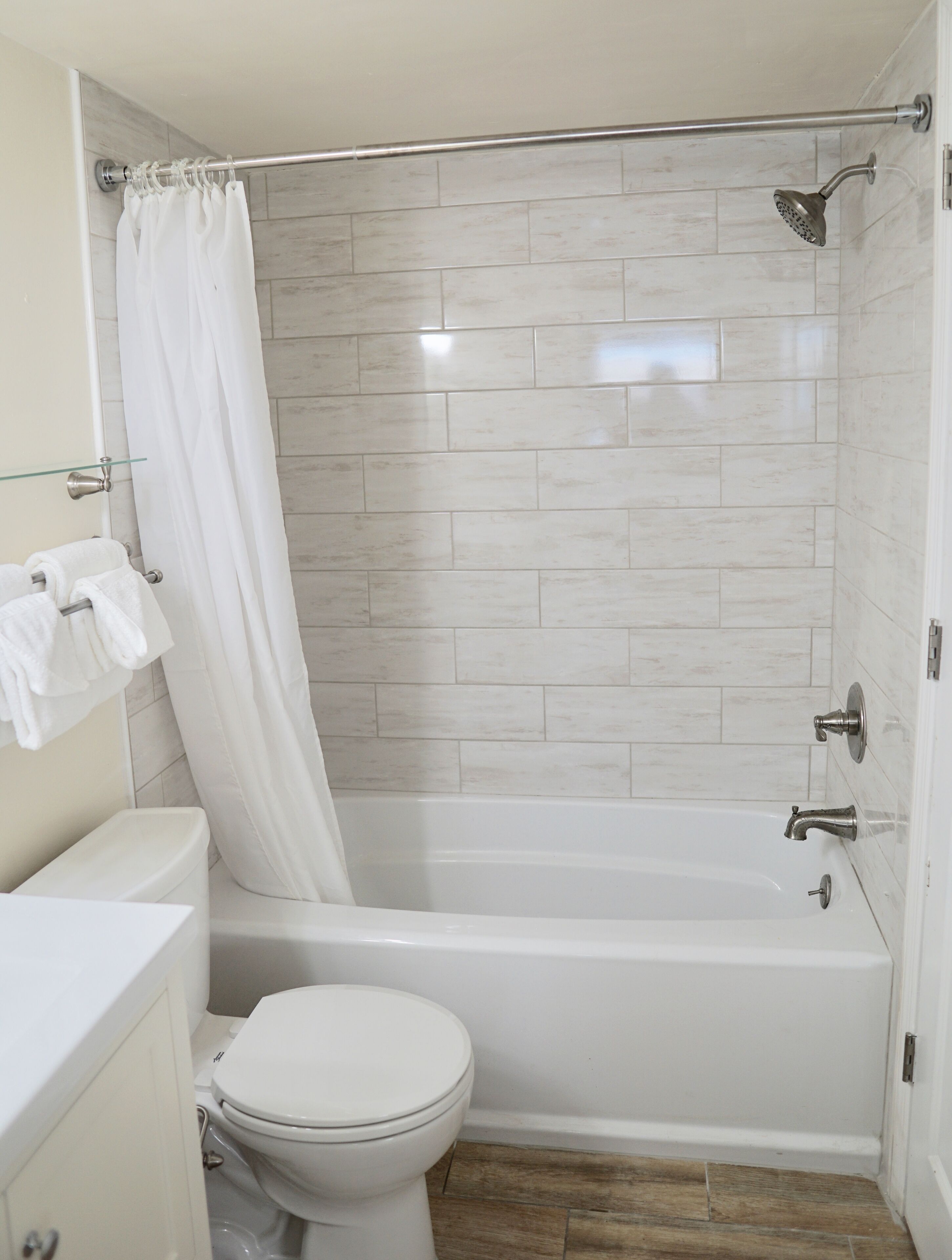 A bathroom with a shower, toilet, and sink.