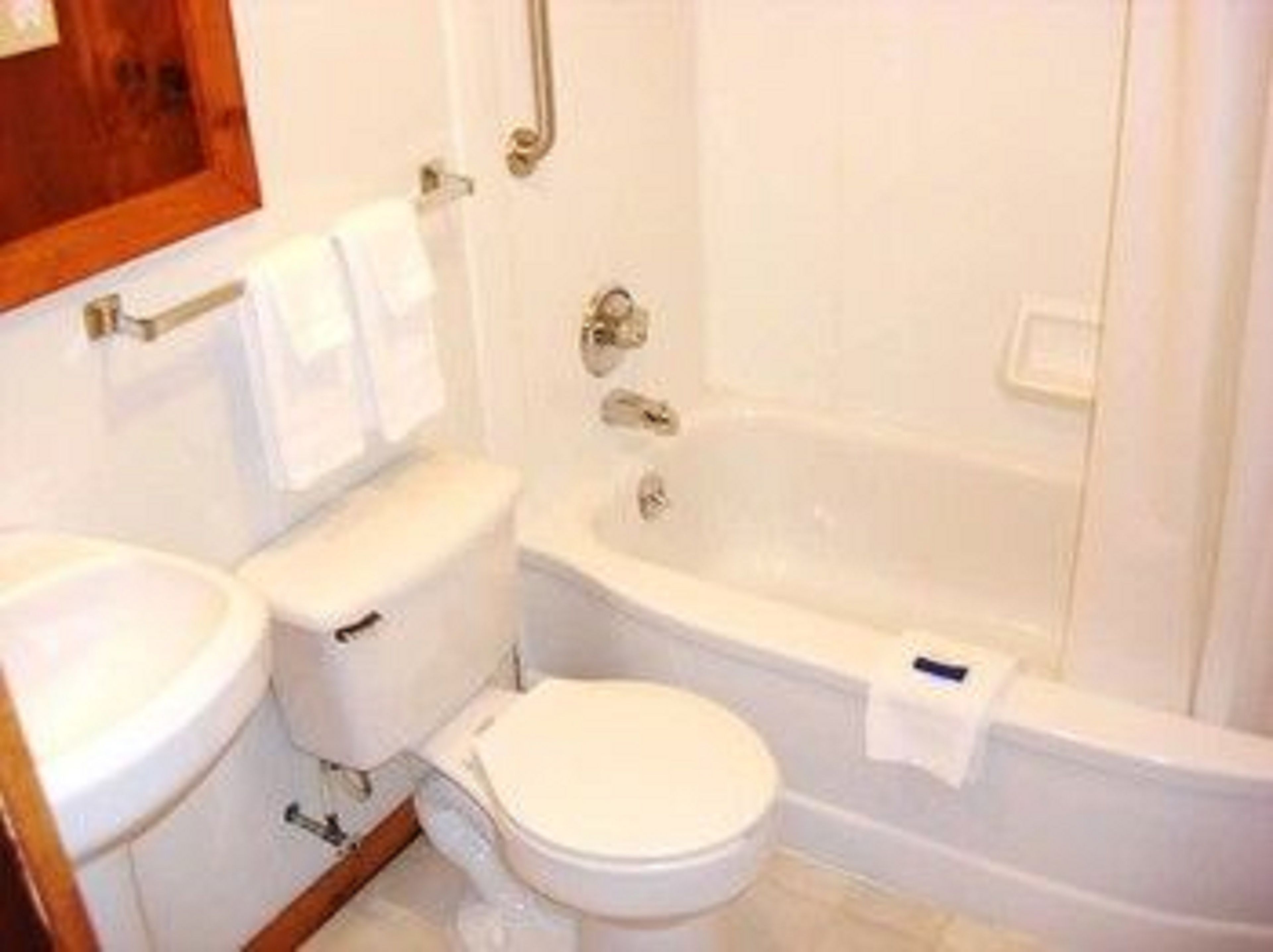 Kombinasi shower/bathtub, handuk,  dan tisu toilet
